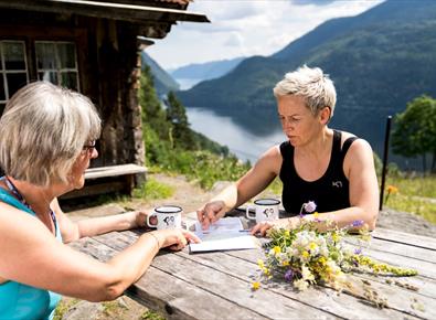 2 damer som sitter ved et bord ved Rui-plassen og ser på kart