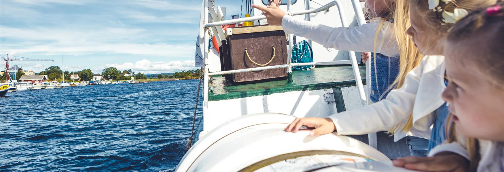 jenter på en båt som ser ut over vannet