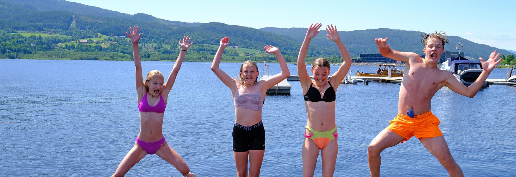 barn i badetøy som hopper og tøyser