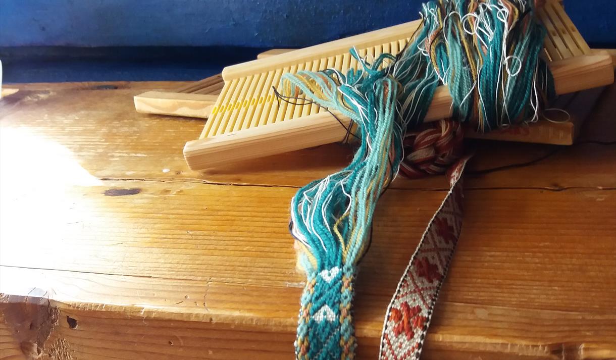 Eksempel på bandveving av bunadsband, handverk i hunsmansstoga i Eidsborg.