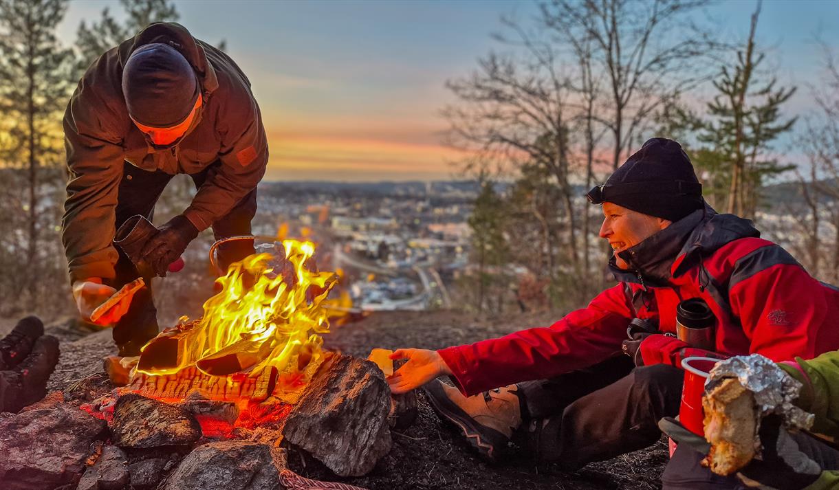 folk sitter rundt et bål på Borgåsen