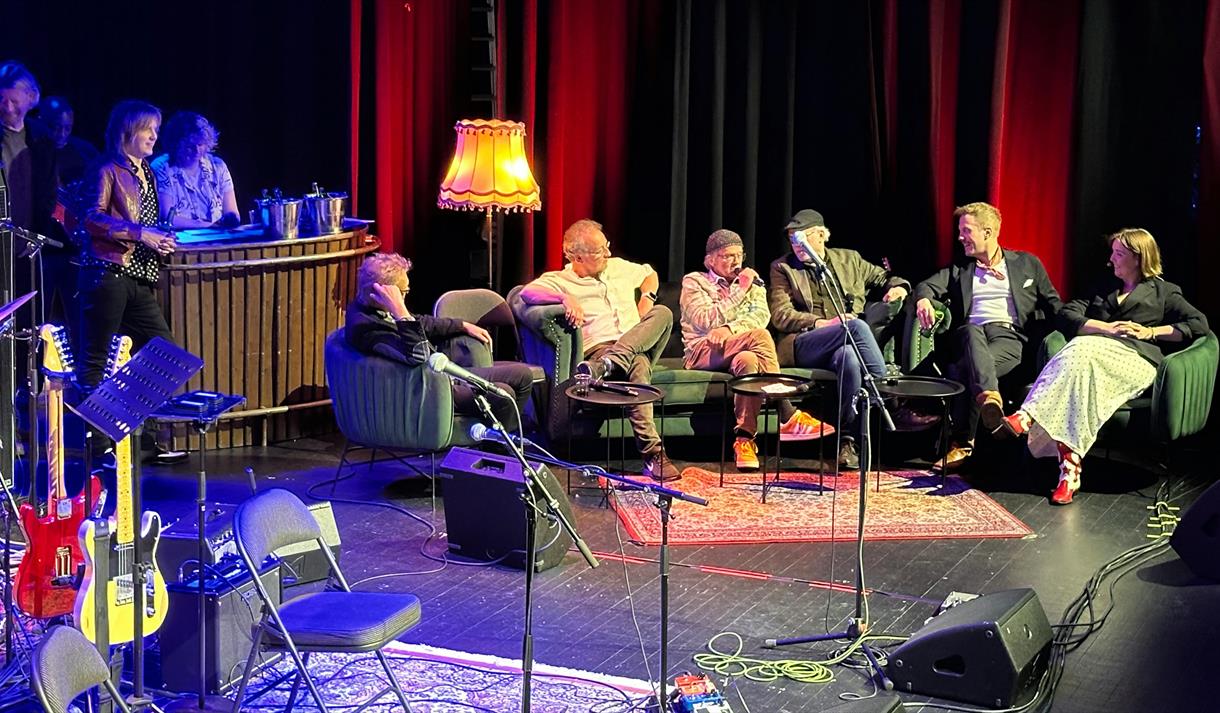 gruppe mennesker som sitter på en scene