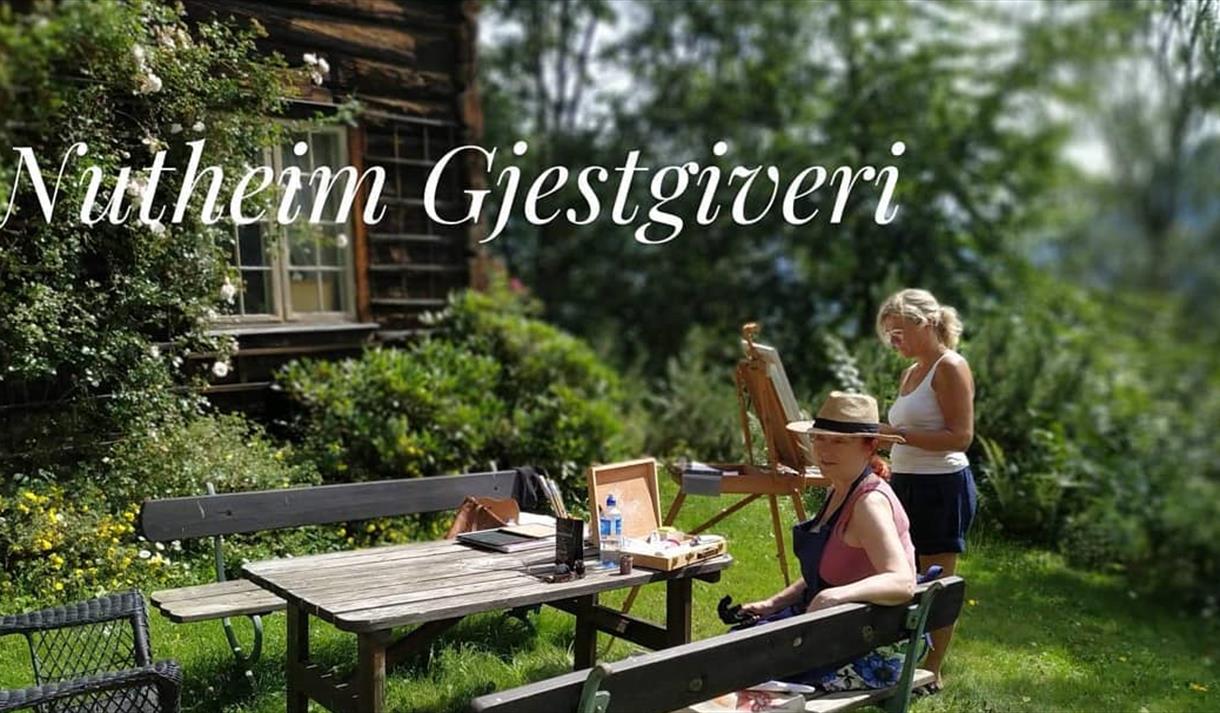 2 damer i en hage maler på lerret. KUNSTKURS uke 26 på Nutheim