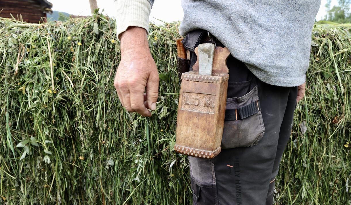 Mann med skopp med bryne i, foran hesje i Eidsborg, Vest-Telemark museum.