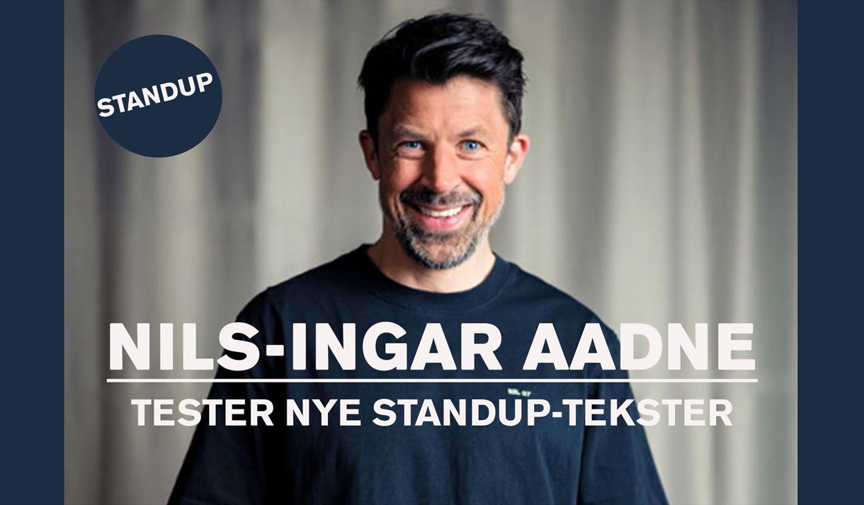 mann med mørkt hår og sort genser, litt skjegg og smiler