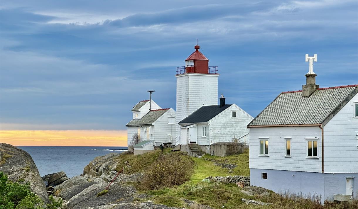 hvite bygg i solnedgang, fjell og hav