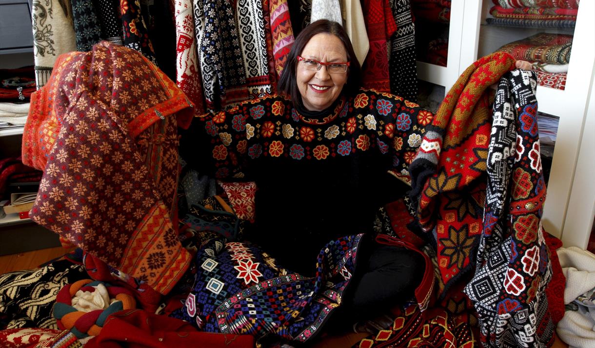 Irene Haugland med smakebitar på sine strikkedesign, Vest-Telemark museum Eidsborg.
