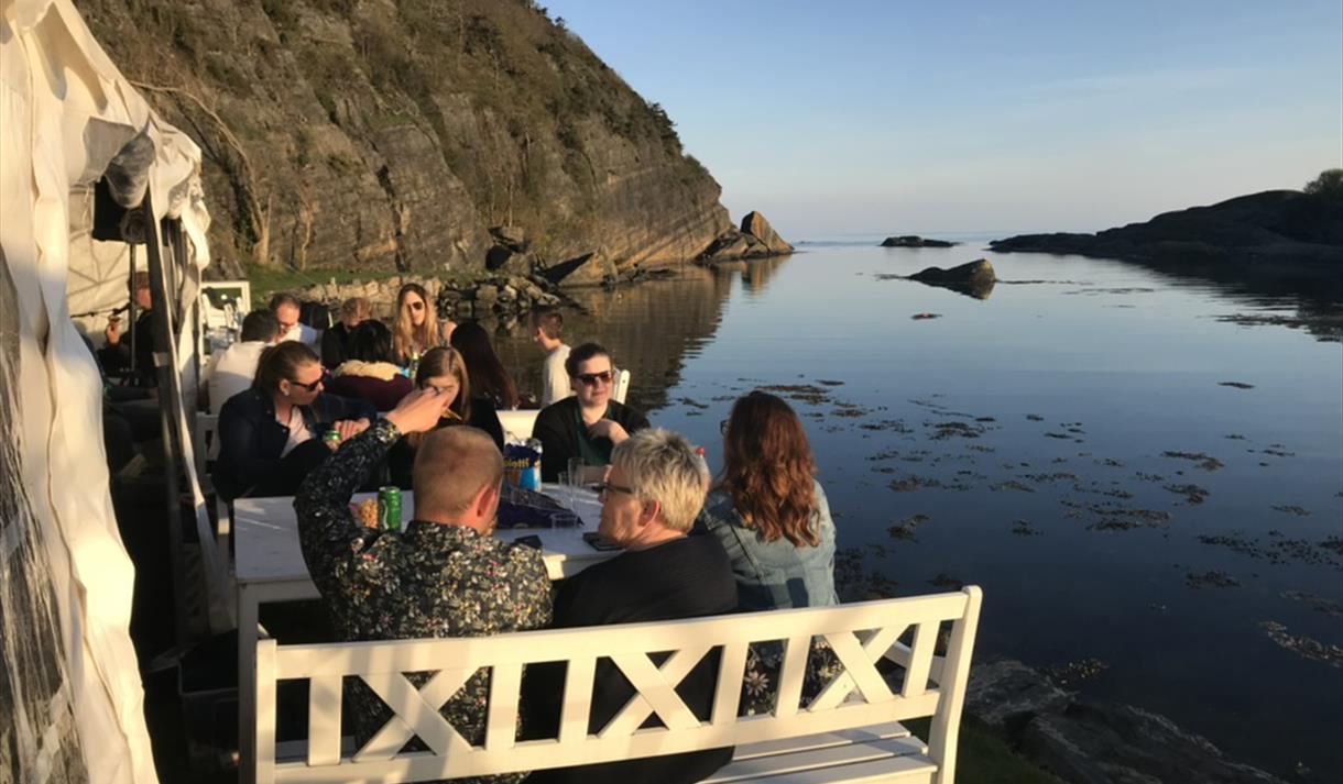 Gruppe som spiser ved sjøen