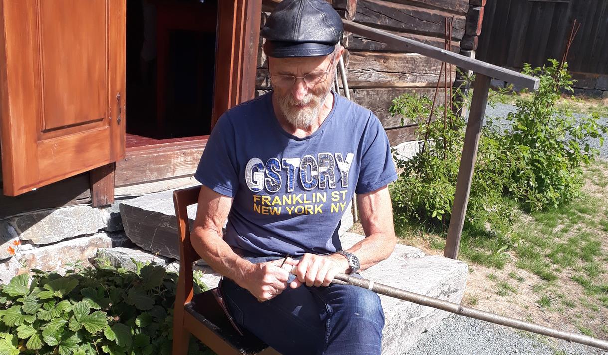 Svein Vinjerui spikkar foran husmannsstoga på Vest-Telemark museum Eidsborg. Svein Vinjerui spikkar foran husmannsstoga på Vest-Telemark museum Eidsborg.
