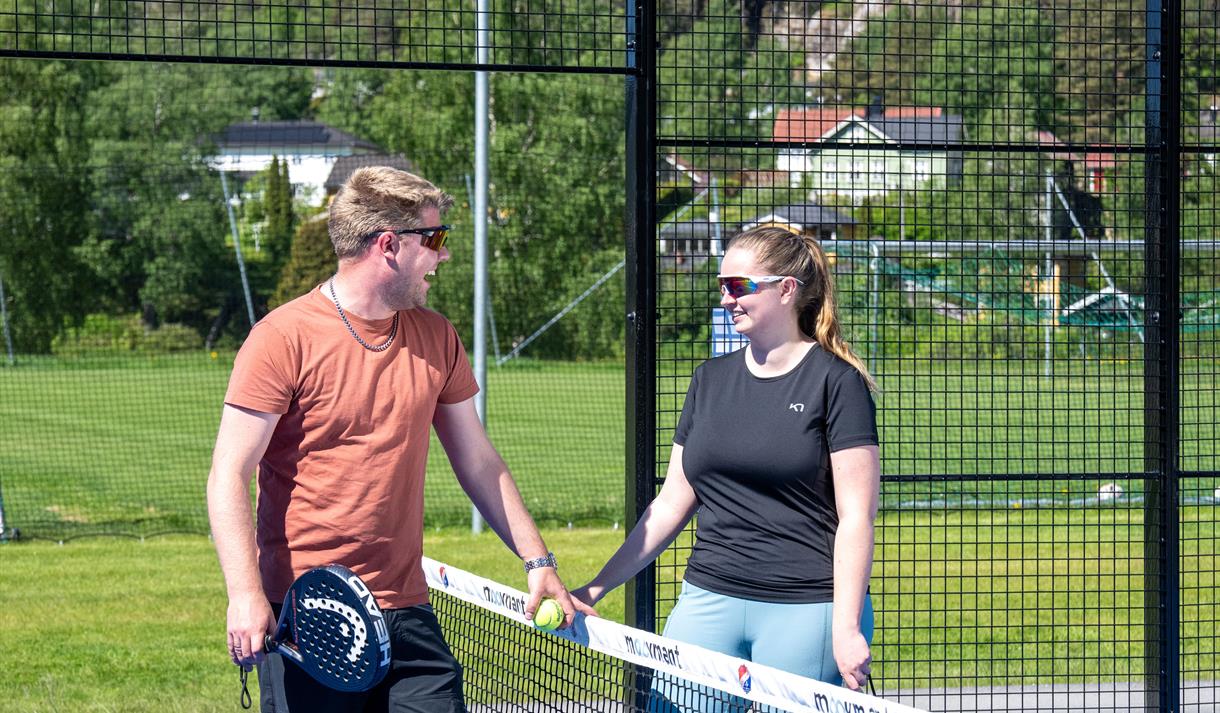 To stykker står ved nettet og snakker.