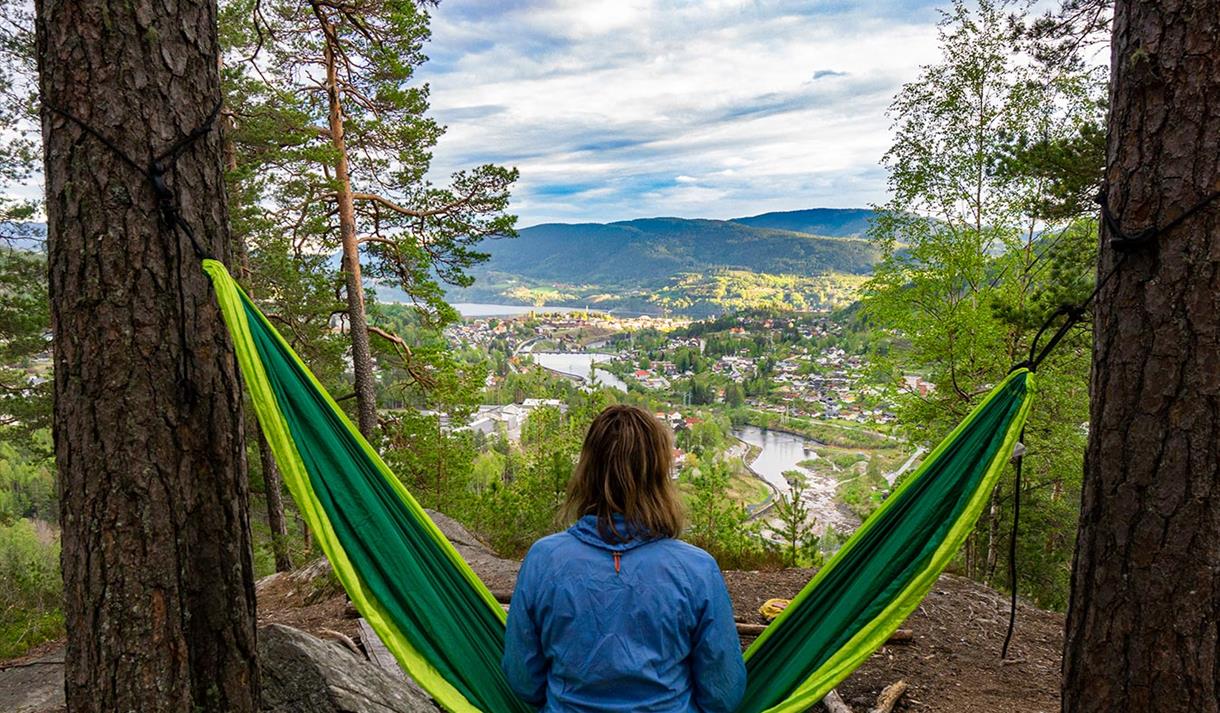 Kvinne i hengekøye som ser utover utsikten på Kåfjellåsen, i Notodden. Foto