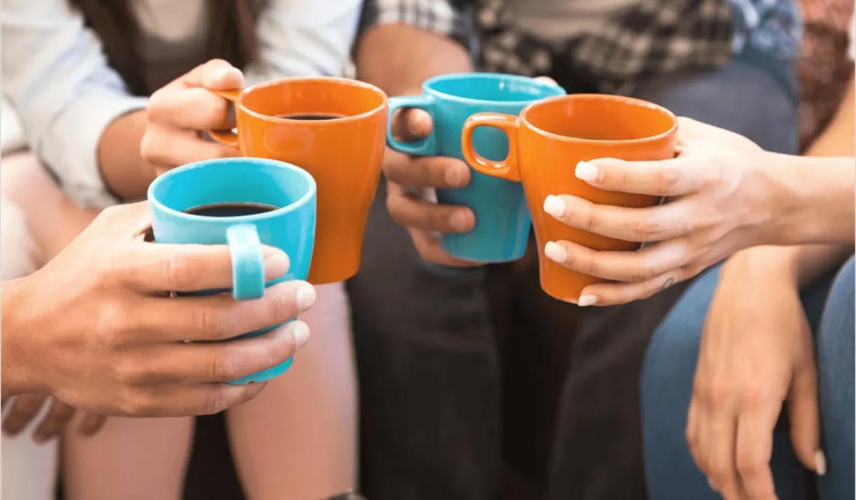 folk som sitter sammen med kopper