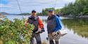 To personer, fiskeguider med fiskestang ved sjøen