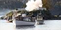 Båter med Kronprinsen og Kronprinsessen ankommer Kragerø og kanoner blir avfyrt på Gunnarsholmen Kystfort