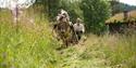 Museumsbonden slår gras med hest. Vest-Telemark museum Eidsborg.