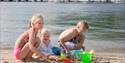 2 barn på badestrand med strandleker