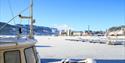 Notodden Motorbåtforenings Gjestehavn vinterstid med snø og Notodden by i bakgrunn. Foto