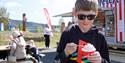 En fornøyd gutt med is foran Herligheten Iskiosk en fin sommerdag i Notodden. Foto