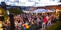 Gjester koser seg på Sommerfest i haven på Becks Brasserie & Bar Osebro med utsikt over Porsgrunnselva.