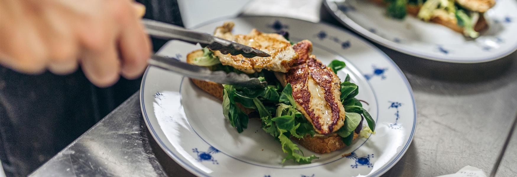 kokk legger mat på tallerken